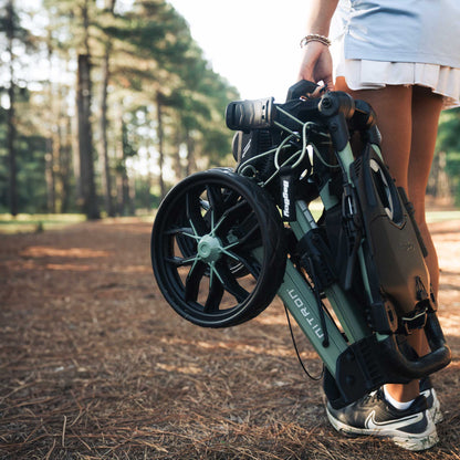 Sage/White Bag Boy Nitron Auto-Open push cart folded and carried in one hand